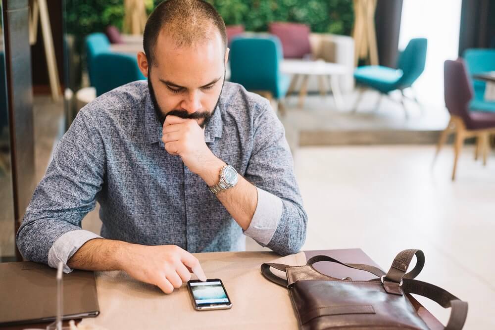 businessman-with-phone-cafe