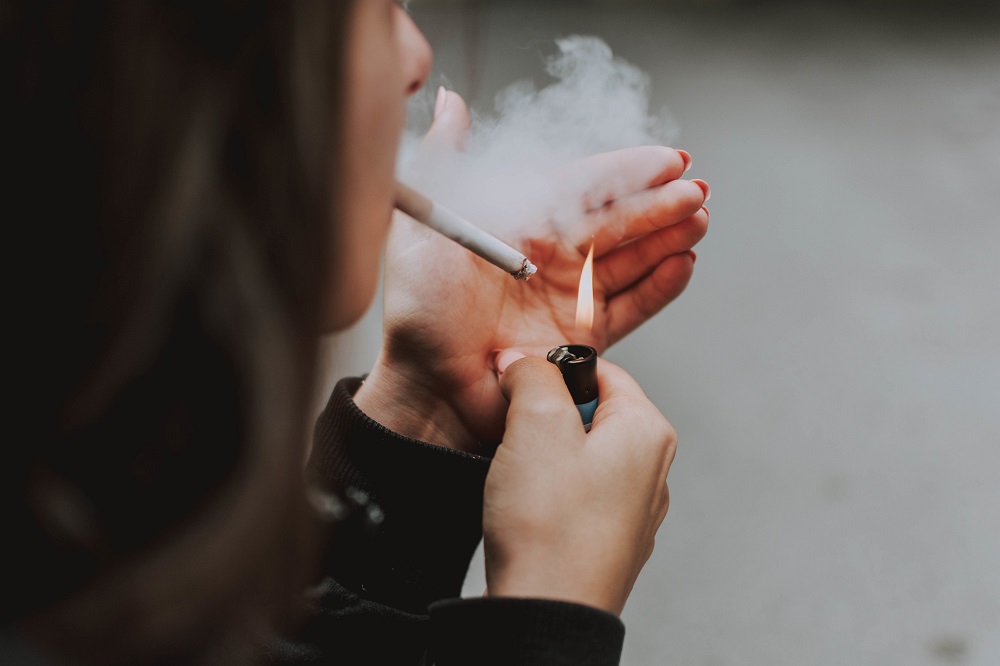 selective-closeup-shot-female-lighting-up-cigarette-with-lighter
